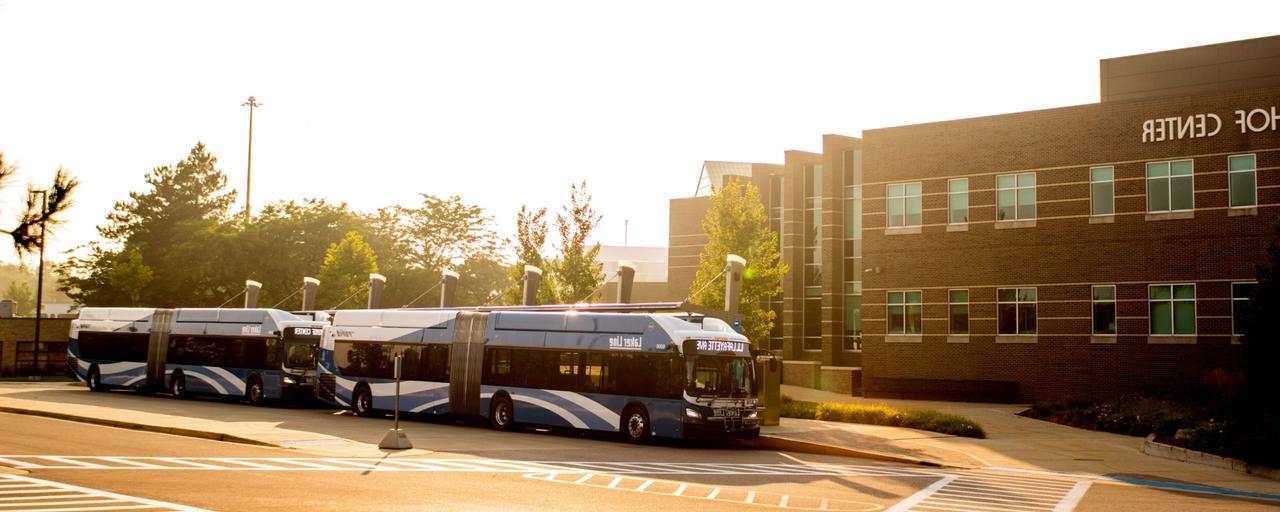 GVSU Kirkhof Center with 公园ed rapid buses at sunrise.